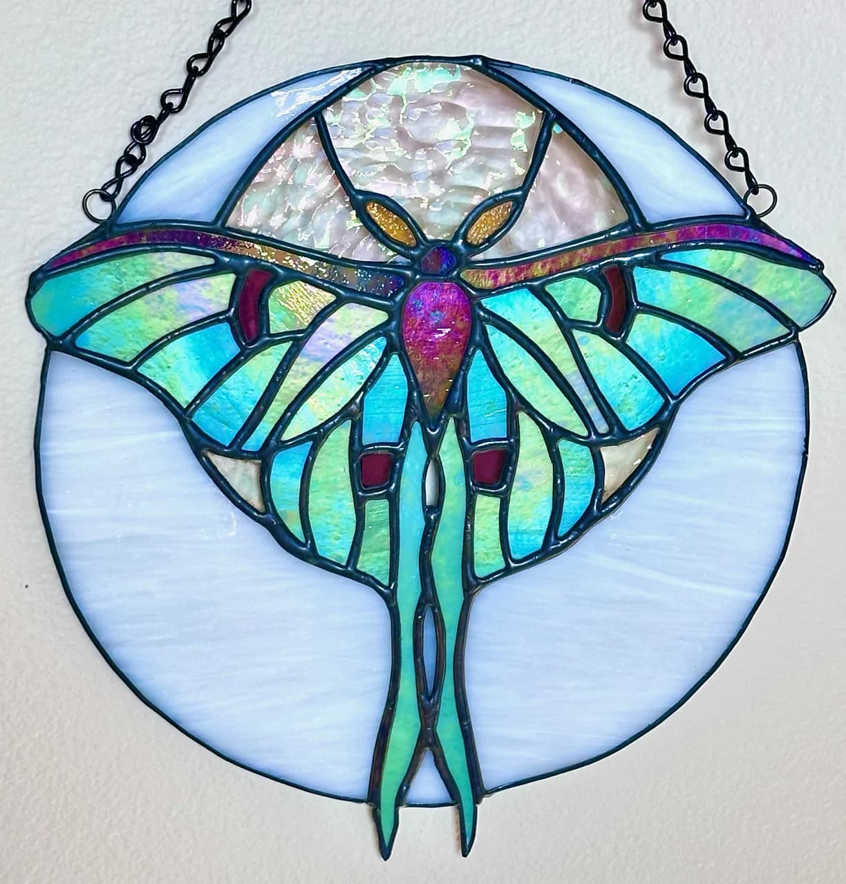 Iridescent teal and magenta luna moth stained glass sun catcher
